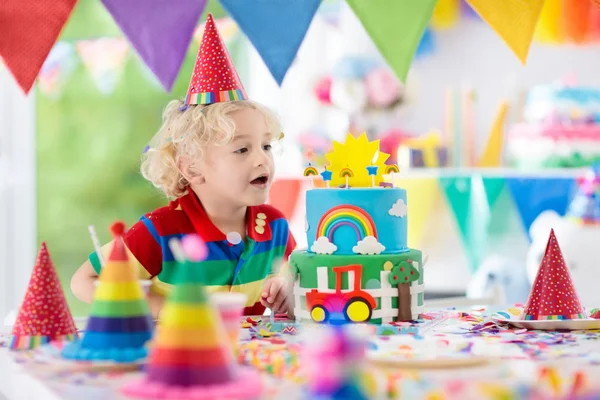 子供の誕生日パーティー。ケーキのろうそくを吹いている子 — ストック写真