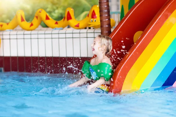 Dziecko na basen slajdów. Dzieci pływać. Woda zabawa — Zdjęcie stockowe