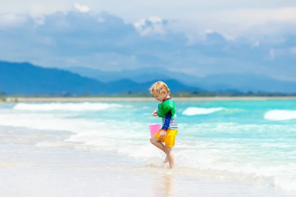 Los niños juegan en la playa tropical. Arena y agua juguete . — Foto de Stock