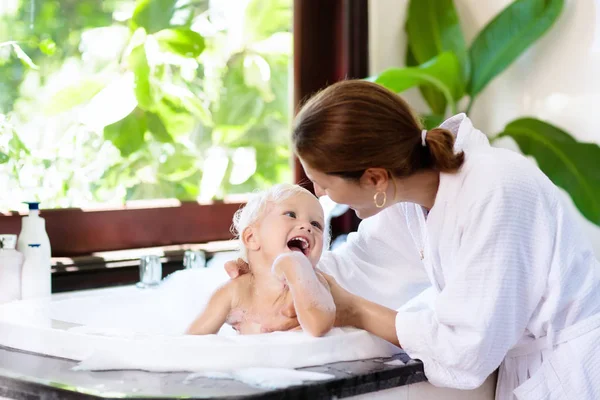 Mother washing baby in bubble bath. Water fun. — Stock Photo, Image