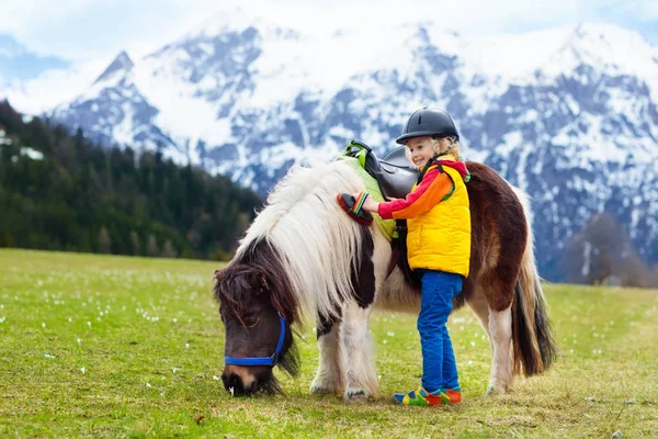 Jazda konna kucyk dla dzieci. Dziecko na koniu w górach Alp — Zdjęcie stockowe