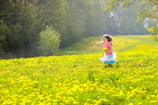 Діти грають. Дитина в полі кульбаби. Літня квітка — стокове фото