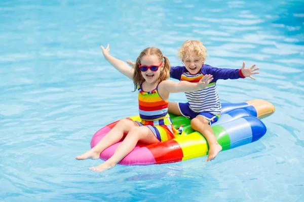 Kids on inflatable float in swimming pool. — Stock Photo, Image