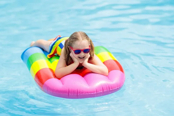 Kind auf aufblasbarem Schwimmer im Schwimmbad. — Stockfoto