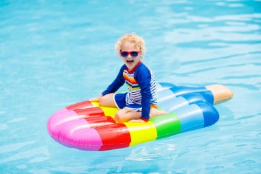 Çocuk yüzme havuzunda şişme kayan nokta üzerinde. 