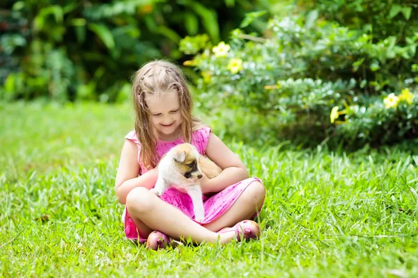 Çocuklar köpekle oynar. Çocuk ve köpek bahçe içinde. — Stok fotoğraf