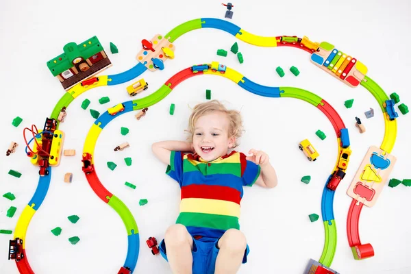 Kind met speelgoed trein. Houten spoorlijn van kinderen. — Stockfoto