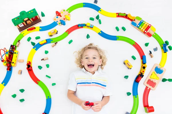 Criança com trem de brinquedo. Crianças ferroviário de madeira . — Fotografia de Stock