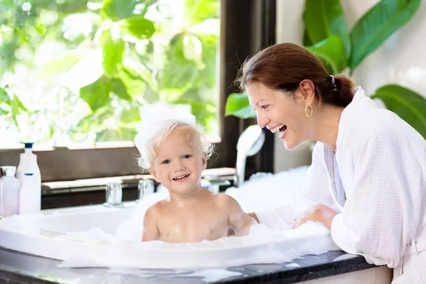 Mamma tvätt baby i bubbelbad. Vatten kul. — Stockfoto