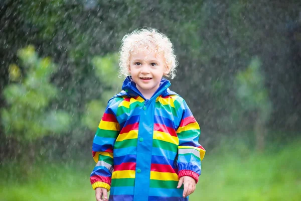 Küçük çocuk yağmurda oynuyor — Stok fotoğraf