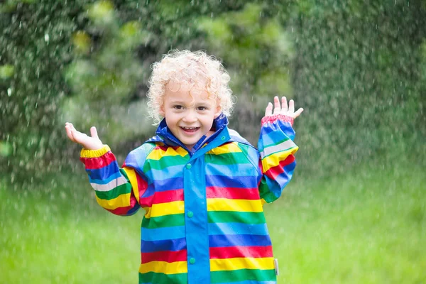 男の子が雨の中で遊ぶ — ストック写真