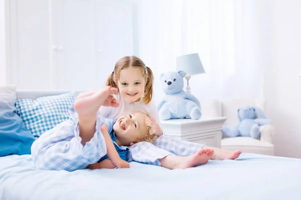 Lapset leikkivät valkoisessa makuuhuoneessa — kuvapankkivalokuva