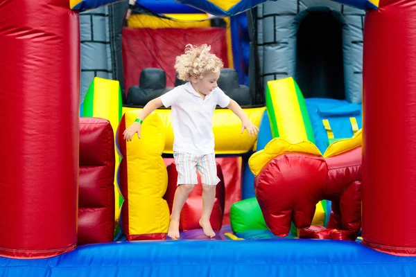Bambino che salta sul trampolino del parco giochi. I bambini saltano . — Foto Stock