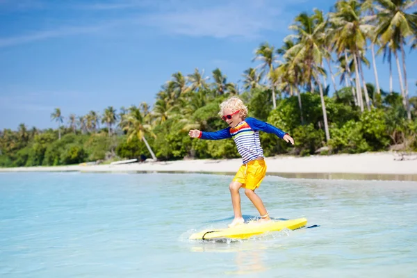 Dítě na tropické pláži. Surfař v oceánu. — Stock fotografie