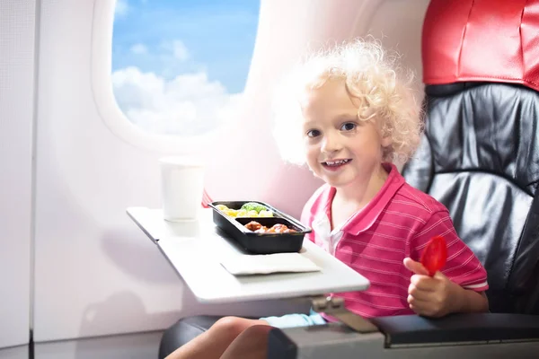 Enfant dans l'avion. Les enfants volent. Repas d'enfants — Photo