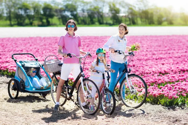 Familia en bicicleta en campos de tulipanes, Holanda — Foto de Stock