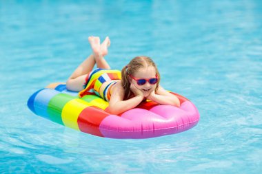 Şişme dondurma float tropikal tatil köyü Açık Yüzme havuzunda mutlu çocuk. Çocuklarla yaz tatili. AIDS yüzmek ve çocuklar için giyim. Su oyuncakları. Renkli salda yüzen küçük kız.