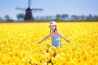 Hollanda yel değirmeni ile Lale çiçek alan çocuk. Çiçek buketi için yay ile beyaz şapkalı küçük Hollandalı kız. Alanları Rüzgar değirmeni, Hollanda'da Lale içinde çocuk.