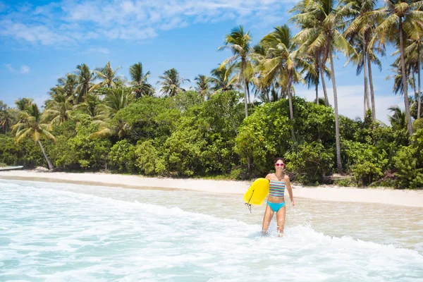 アジアの熱帯のビーチでサーフィン ビキニの若い女性 海の波のサーフィン ボードの女の子 アクティブなウォーター スポーツ フィットのトーンのボディを 女性アスリート水泳します エキゾチックな海でサーファー 泳ぐと目の摩耗 — ストック写真
