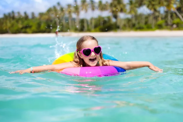 美しいビーチでインフレータブルリングを持つ子供 エキゾチックな海で泳いでいる少女 子供と海の休暇 子供たちは夏のビーチで遊ぶ 水の楽しみ 子供たちは泳ぐ 熱帯島での家族の休日 — ストック写真