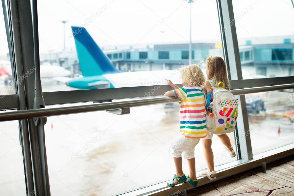 Kids at airport. Children look at airplane. Traveling and flying with child. Family at departure gate. Vacation and travel with young kid. Boy and baby before flight in terminal. Kids fly a plane.