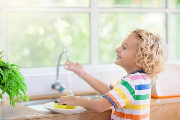 Child washing dishes.