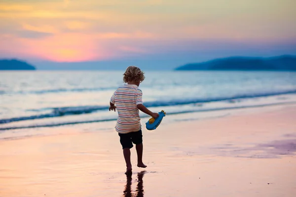 Okyanus plaj üzerinde oynayan çocuk. Gün batımı denizde evlat. — Stok fotoğraf