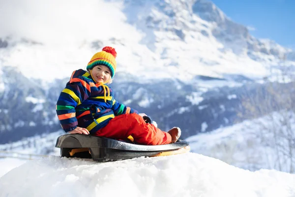 Kızak süren çocuk. Çocuk kayağı. Kızaklı çocuk. — Stok fotoğraf