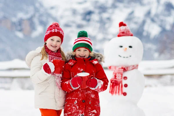 Child building snowman. Kids build snow man. — Stock Photo, Image
