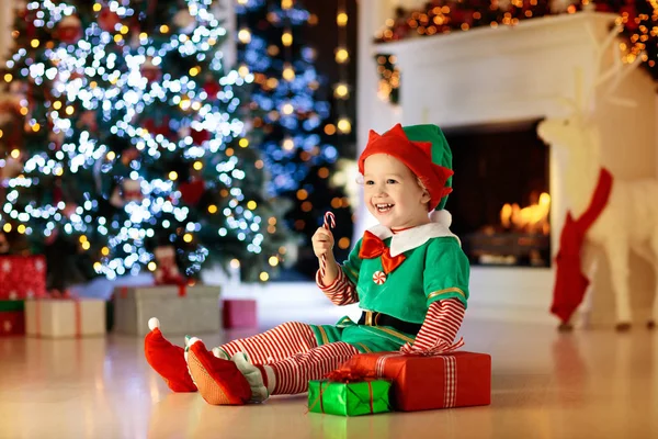 Kids at Christmas tree. Children open presents — Stock Photo, Image