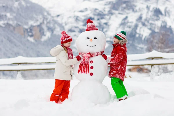 Bambino pupazzo di neve. Bambini costruire uomo di neve . — Foto Stock