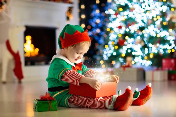 Crianças na árvore de Natal. Crianças presentes abertos — Fotografia de Stock