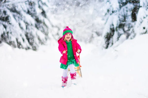 坐雪橇的女孩。 孩子们滑行。 在雪橇上的孩子 — 图库照片