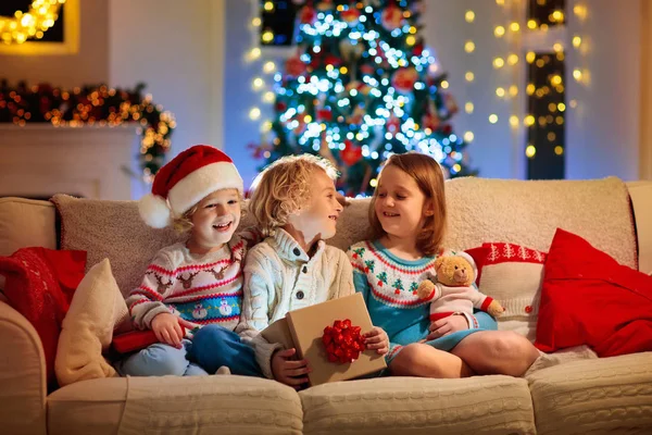Niño en el árbol de Navidad. Niños en la chimenea en Navidad —  Fotos de Stock