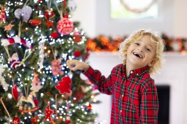 Noel ağacını süsleyen çocuk. Xmas arifesindeki çocuk.