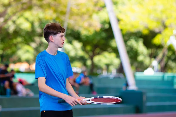 Junger Mann spielt Tennis auf offenem Platz — Stockfoto