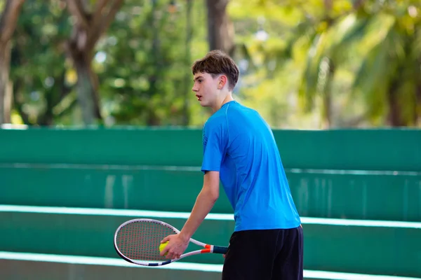 Mladý muž hraje tenis na otevřeném kurtu — Stock fotografie