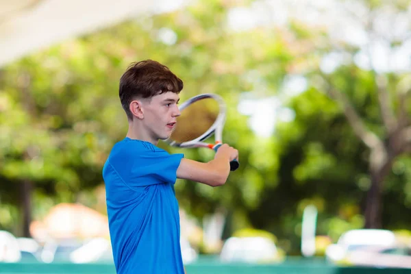 Joven jugando al tenis en cancha abierta — Foto de Stock