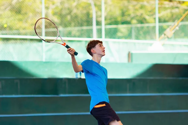 Jeune homme jouant au tennis sur terrain ouvert — Photo