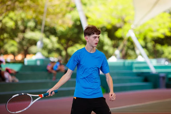 Junger Mann spielt Tennis auf offenem Platz — Stockfoto