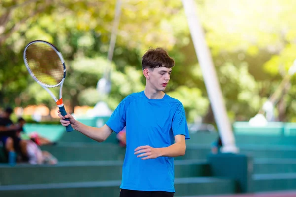Giovane uomo che gioca a tennis su campo aperto — Foto Stock