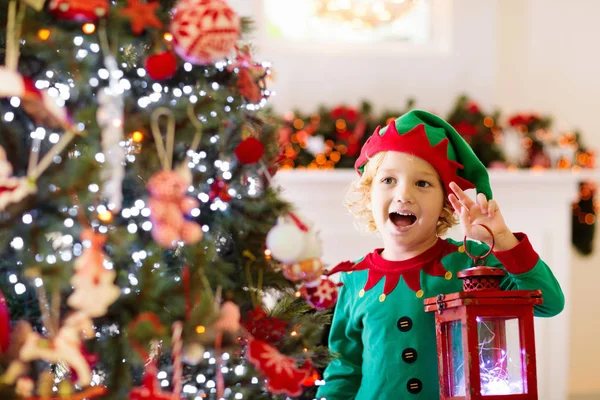 Een kerstboom versieren. Kind op kerstavond. — Stockfoto