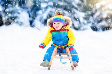 Çocuk kızağı binmek. Kızakla çocuk. Kızak ile çocuk