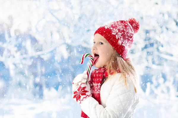 Bambino con bastoncino di zucchero sulla fiera invernale — Foto Stock