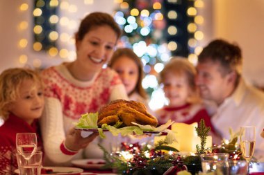 Çocuklu bir aile Noel yemeğini ağaçta yiyor.