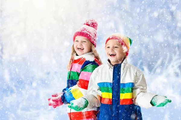 Kids playing in snow. Children play outdoors in winter snowfall. — Stock Photo, Image