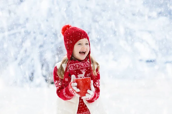 Barn dricker choklad på julen i snö — Stockfoto