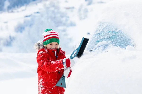 Enfant balayant la voiture. Enfant avec brosse à neige hiver — Photo