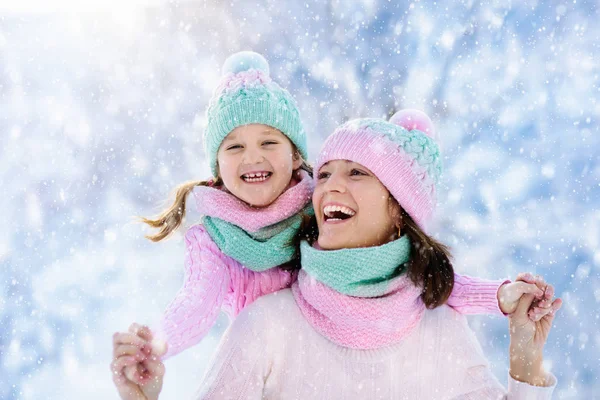 母亲和孩子在雪中编织冬帽. — 图库照片