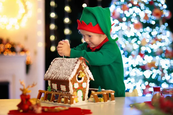子供たちはジンジャーブレッドハウスを焼く。家でクリスマス. — ストック写真